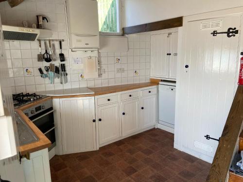 莱姆里吉斯Dolphin Cottage Lyme Regis的厨房配有白色橱柜和白色家电