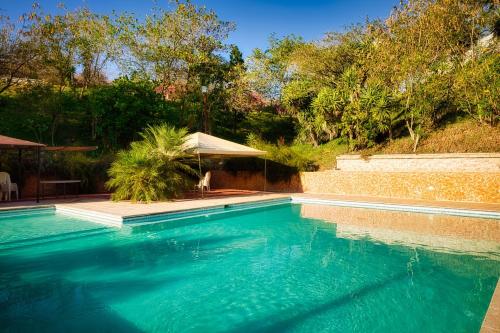 SanarateCasa Santa Teresita - Cabaña tipo glampling的庭院里的一个蓝色海水游泳池