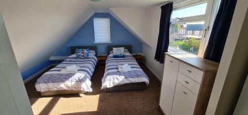 桑当花坛假日公寓的配有两张床铺的蓝色墙壁和窗户
