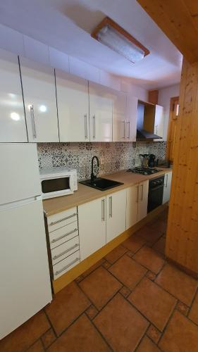 La TobaAlojamiento Rural Casa Inocente的厨房配有白色橱柜和水槽
