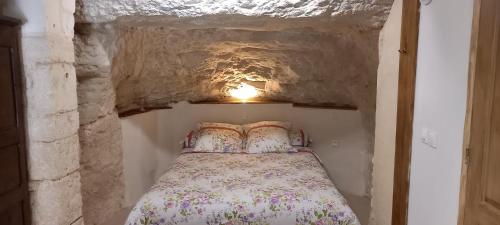 Civray-de-Tourainegite-civray-de-touraine TROGLO de Denise的一间小卧室,在洞穴里配有一张床铺