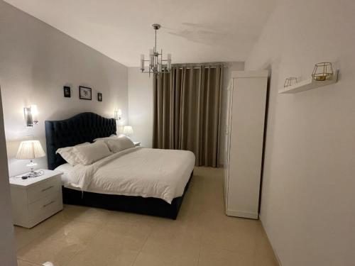 半月湾سافانا امواج Amwaj savana的一间卧室配有一张大床和一个吊灯。