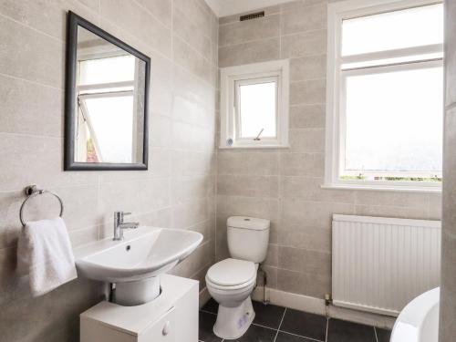 滨海绍森德Ninety Eight的浴室配有盥洗池、卫生间和镜子。