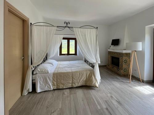 San Mauro CastelverdeAntico Borgo Buonanotte的一间卧室设有一张天蓬床和一个壁炉