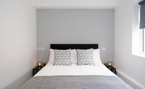 利物浦The Kop End Hotel by Serviced Living Liverpool的一间卧室配有带白色床单和枕头的床。