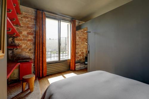 巴黎Appartement artiste atelier bail mobilité Palais Royal的一间卧室设有一张床和一个大窗户