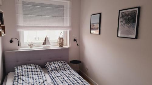 里沃Apartament Klifowa Rewal 16的一间卧室配有带两个枕头的床和窗户
