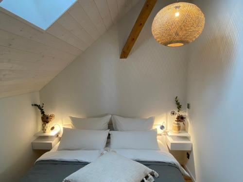 AitrachFerienwohnung d.d. Chalet的卧室配有带白色枕头和吊灯的床。