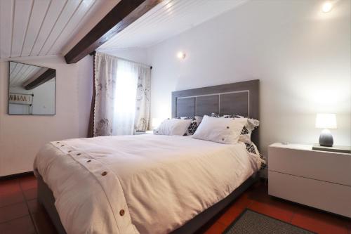 GinetesCasa Quinta das Férias的卧室设有一张白色大床和一扇窗户。