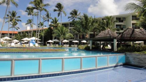嘎林海斯港Flat Experience Marulhos Resort的棕榈树和遮阳伞度假村的游泳池