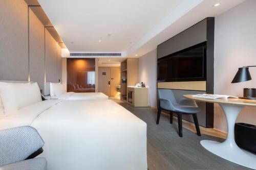 安庆安庆吾悦广场亚朵酒店的酒店客房设有一张大床和一张书桌。