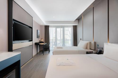 景洪市西双版纳告庄亚朵酒店的酒店客房设有两张床和一台平面电视。