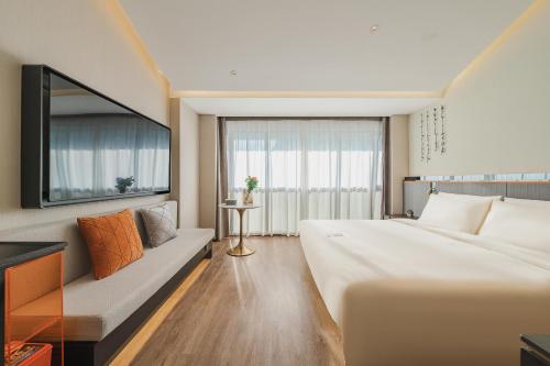 无锡无锡南长街亚朵S酒店的酒店客房设有一张大床和一张沙发。
