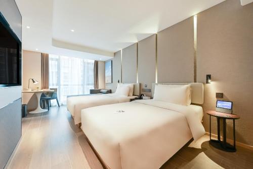 鄂州鄂州市政府亚朵酒店的酒店客房配有两张床和一张书桌