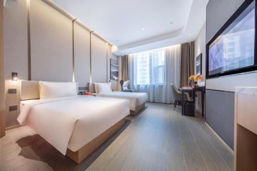 太原太原长风商务区万象城亚朵酒店的酒店客房设有两张床和一台平面电视。