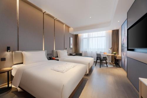 胶州青岛胶东国际机场亚朵酒店的酒店客房设有两张床和一台平面电视。