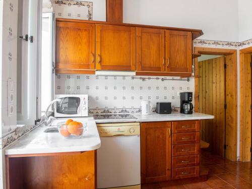 新蒙特莫尔卡萨达菲盖拉农家乐的厨房配有木制橱柜,柜台上放着一碗水果