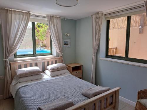 米德希特本-古里安沙漠玫瑰公寓的一间卧室配有一张带两个枕头的床
