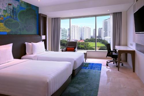 雅加达雅加达马腰兰美爵酒店 的酒店客房设有两张床、一张书桌和一个窗户。