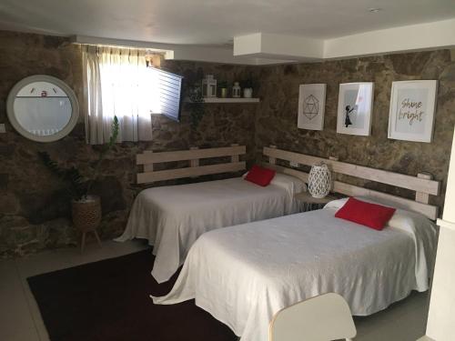 奥亚Casa Carola的一间卧室配有两张带红色枕头的床