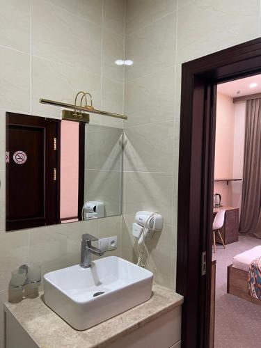 撒马尔罕Mahmud Hotel的一间带水槽和镜子的浴室