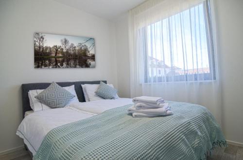 米库洛夫Palm Garden Apartment 1的一间卧室配有两张带毛巾的床