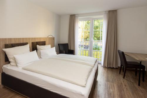 杰斯帝堡耶斯特伯格霍夫酒店的一间卧室配有一张床、一张桌子和一个窗户。