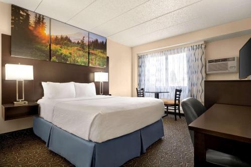 柯林斯堡柯林斯堡戴斯酒店的酒店客房设有一张大床和一张书桌。