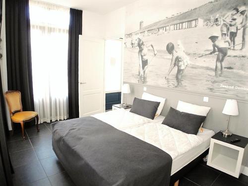 栋堡DAC50 Luxurious apartment Domburg的一间卧室配有一张床,还有一幅游泳者的画作