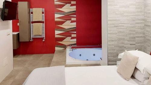 内图诺Sweet Home & Wellness Luxury Apartment的带浴缸和红色墙壁的浴室