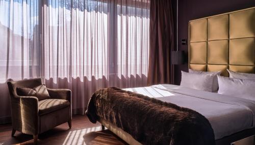 美因河畔法兰克福Roomers, Frankfurt, a Member of Design Hotels的配有一张床和一把椅子的酒店客房