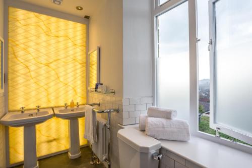 贝里Eagle and Child, Ramsbottom的浴室设有两个盥洗盆和黄色的淋浴帘