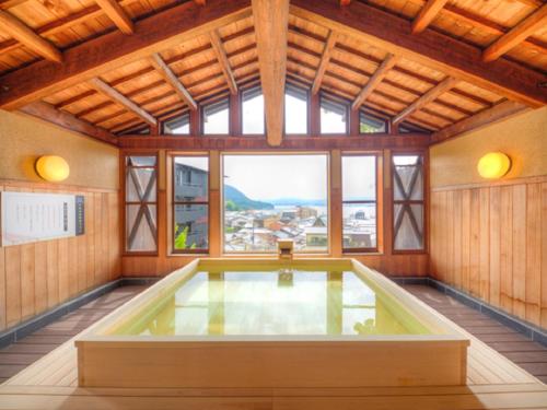 宫岛LiVEMAX RESORT Aki Miyajima的大型客房设有大窗户和游泳池。