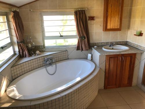 温特顿Bee’s Knees Cottage的带浴缸和盥洗盆的浴室