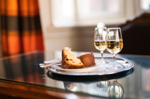 斯特拉斯堡Hotel Suisse的一块面包和两杯葡萄酒