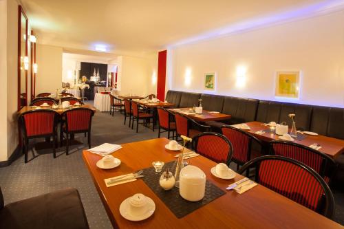 科隆皇家中心酒店的用餐室配有木桌和椅子