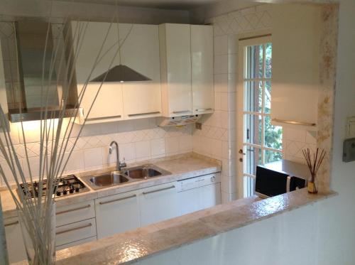 钦克亚勒Holiday home Villetta Cinquale的厨房配有白色橱柜和水槽