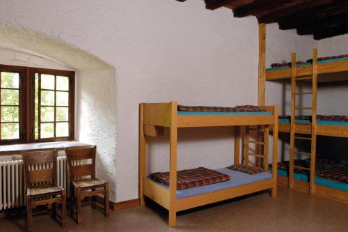 MariasteinMariastein-Rotberg Youth Hostel的客房设有双层床和桌椅。