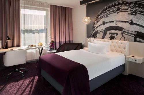 曼海姆多林空曼赫姆酒店的酒店客房设有一张大床和一张书桌。