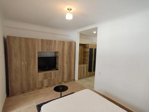 RoşuMilitari Studio的一间设有床铺和墙上电视的房间