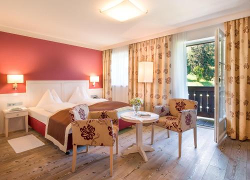 萨尔茨堡底格斯伯格浪漫酒店的酒店客房带一张床、一张桌子和椅子