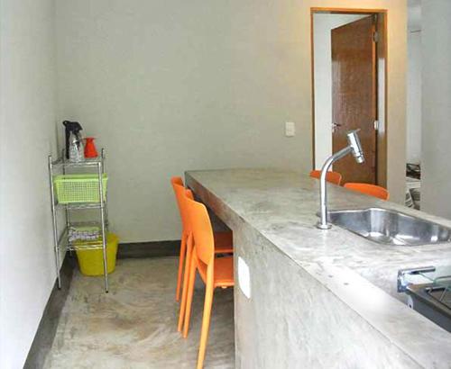 乌巴图巴Vila Praiana的厨房配有水槽和橙色椅子