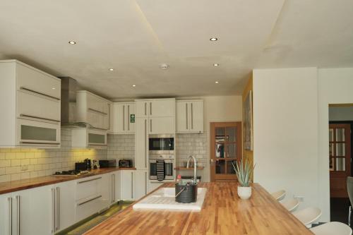 AttleboroughModern Spacious House - Sleeps 16, Free Parking, Sun Terrace的厨房配有白色橱柜和木制台面