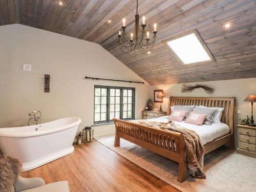 肯德尔The Hare's Shack的一间卧室设有一张大床和一个浴缸