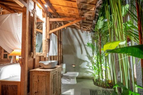 坎古Bajalo Cottage Canggu的一间带卫生间和一些植物的浴室