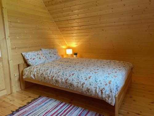 BodzentynDomek na Wsi的小木屋内一间卧室,配有一张床