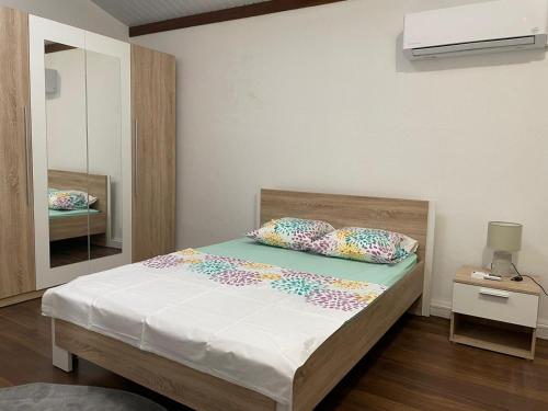 库鲁SPACIEUX T5的一间卧室配有带白色床单和色彩缤纷的枕头的床。