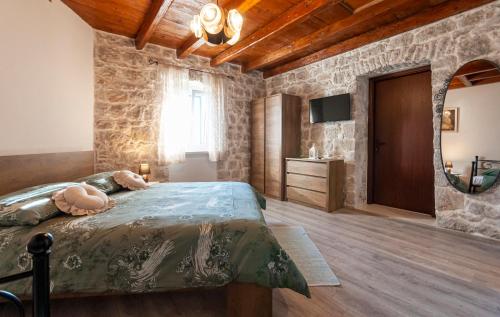 耶塞尼采New Villa OLE, stone house, sea view, jacuzzi的一间卧室设有一张床和石墙