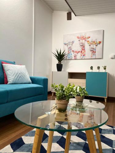 库鲁CHARMANT T2的客厅配有玻璃桌和蓝色沙发