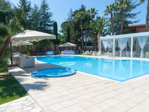 安德里亚B&B Villa Adriana的棕榈树度假村内的游泳池